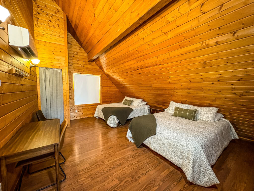 Un lit mezzanine Queen dans une cabine mezzanine partagée à deux lits Queen avec salles de bains partagées
